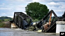 Several train cars are immersed in the Yellowstone River after a bridge collapse near Columbus, Mont., June 24, 2023. 