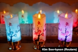 Surrounded by candles, Lee Kyoung-hyun, a YouTuber shaman, prays for people in Seoul, South Korea, May 13, 2024. (REUTERS/Kim Soo-hyeon)