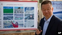 资料照：中国政府组织外国记者参观新疆维吾尔自治区阿克苏期间，新疆华孚色纺集团有限公司总经理李强在其公司宣传板前讲话。（2021年4月20日）