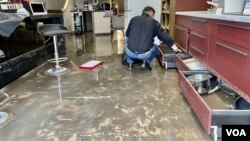 受世紀大暴雨影響，港島灣仔天樂里一間廚具店水浸約一英呎，9月9日水退後職員忙於清理店舖。(美國之音/湯惠芸)