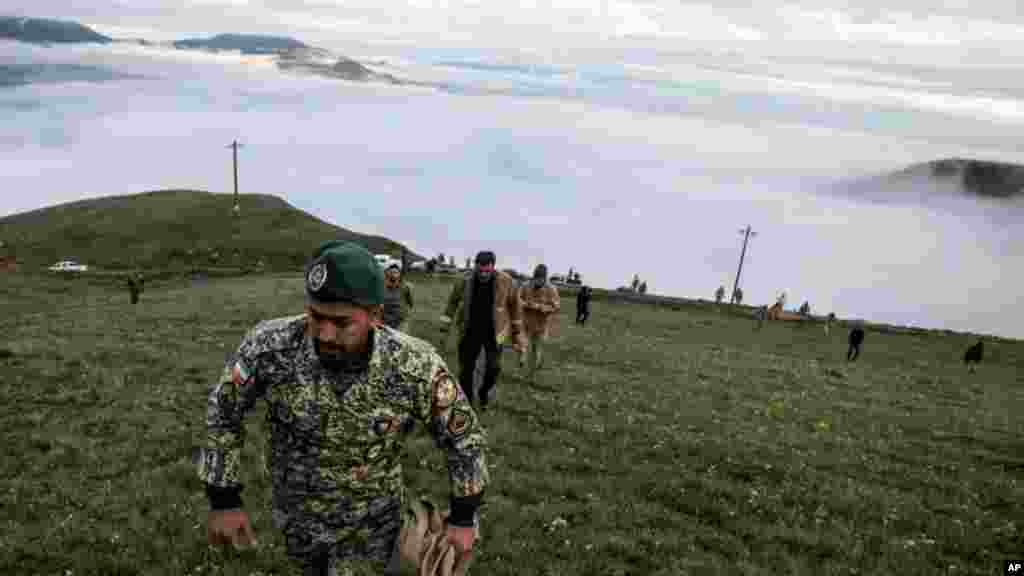 En esta fotografía proporcionada por la agencia de noticias Moj, miembros del equipo de rescate buscan los restos del helicóptero que transportaba al presidente iraní Ebrahim Raisi después de que se estrellara en Varzaghan, en el noroeste de Irán, el 20 de mayo de 2024.