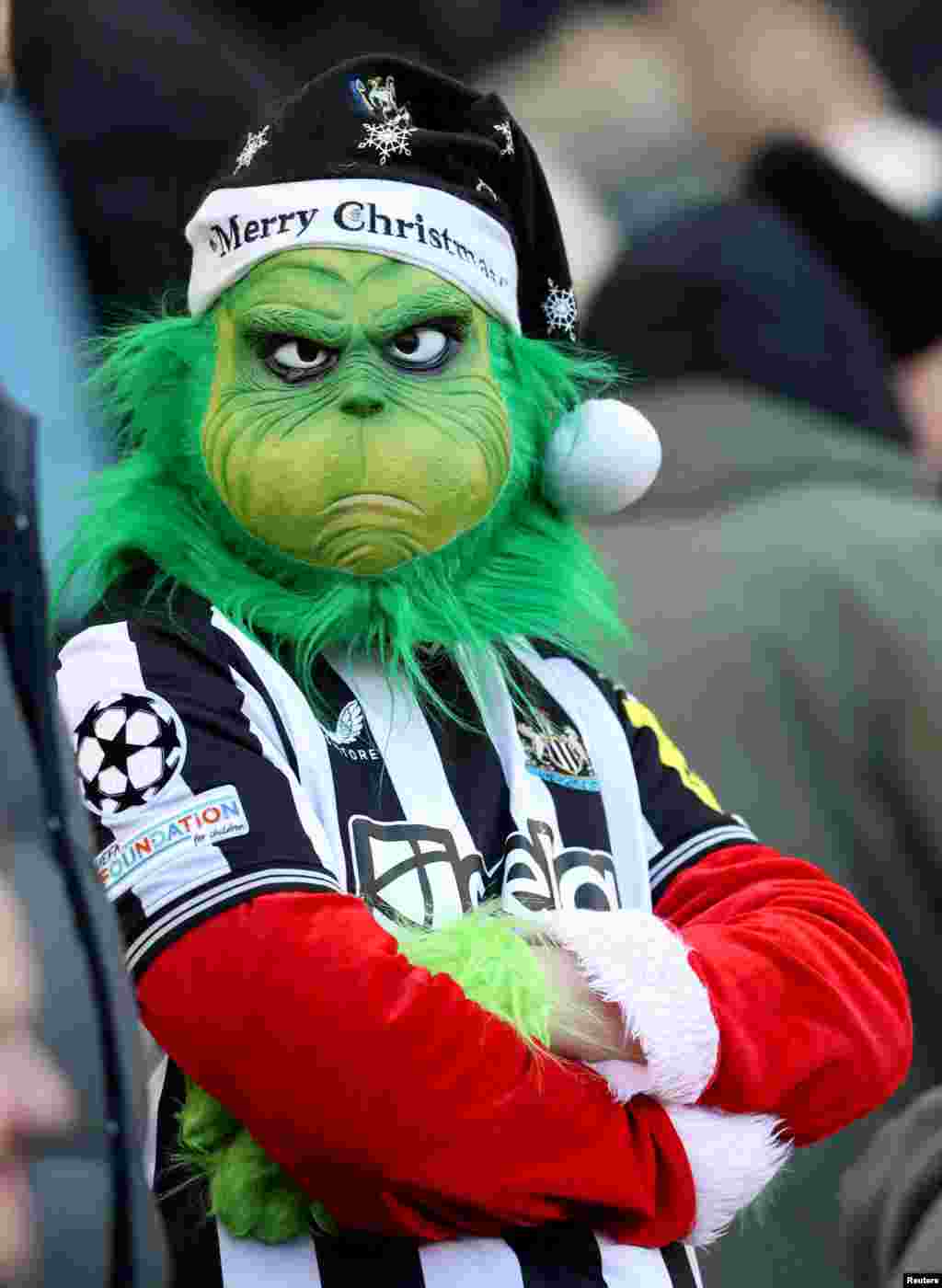 Penggemar Newcastle United mengenakan topeng Grinch saat menghadiri pertandingan sepak bola Liga Utama Inggris antara Newcastle United dan Nottingham Forest di St. James 'Park di Newcastle-upon-Tyne, Inggris.