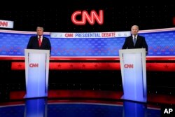 Presiden Joe Biden, kanan, dan calon presiden dari Partai Republik mantan Presiden Donald Trump, kiri, berdiri saat istirahat dalam debat presiden yang diselenggarakan oleh CNN, Kamis, 27 Juni 2024, di Atlanta. (Foto: AP)