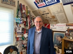 Jonathan Salant stoji ispred stotina pres propusnica koje je sakupio tokom svojih decenija izvještavanja iz Washingtona. (Foto: VOA/Liam Scott)