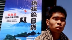 一名男子走過北京秀水街頭一幅「拒絕日貨」的宣傳牌。 （2012年9月17日）