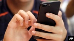 A unidentified person uses a smartphone in Chicago, Sept. 16, 2017. (AP Photo, File)