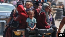 Wapalestina wakiwa wamepanda mkokoteni katika eneo lawatu waliopoteza makazi huko Rafah Juni 19, 2024, Picha na Bashar TALEB / AFP