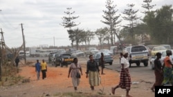 Pessoas caminham ao longo de uma rua em Maputo, a 4 de setembro de 2010. 