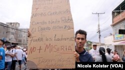 "Cuando nadie roba, el dinero alcanza", se lee en una pancarta que carga un venezolano que participó en acto convocado por la oposición en La Victoria, Venezuela el 18 de mayo de 2024.