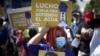 Una mujer sostiene un cartel que dice: "Lucho por la vida, defiendo el agua" durante una protesta para conmemorar el día Mundial del Agua, en San Salvador, el 22 de marzo de 2022.