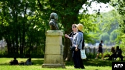 Dos mujeres miran el busto del líder de la Revolución haitiana, el general Toussaint Louverture, el 5 de mayo de 2018 en Burdeos, Francia, durante una visita guiada sobre la historia de la esclavitud.
