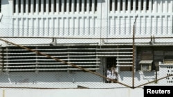 Los reclusos miran hacia el exterior a través de una puerta con barrotes en la prisión cubana para hombres conocida como "Combinado del Este", en las afueras de La Habana, Cuba, el 31 de marzo de 2004.