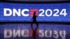 Seorang peserta berjalan melewati layar di United Center, menjelang Konvensi Nasional Demokrat (DNC) di Chicago, Illinois, AS, 19 Agustus 2024. (Kevin Wurm/REUTERS)