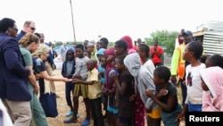 美國第一夫人吉爾·拜登2023年2月23日在納米比亞溫得和克向兒童分發糖果。