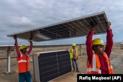 คนงานติดตั้งแผงโซลาร์เซลล์ ของโครงการโรงไฟฟ้าพลังงานหมุนเวียน คาฟดา ของอินเดีย