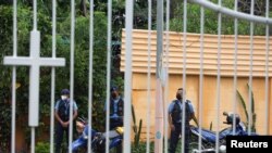 ARCHIVO - Agentes de la Policía vigilan afuera de una iglesia católica donde Rolando Álvarez, obispo de la Diócesis de Matagalpa y Estelí y crítico del presidente Daniel Ortega, se refugia alegando haber sido atacado por la policía, en Managua, el 20 de mayo de 2022. 
