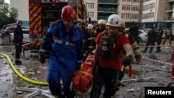 Rescuers carry a woman extracted from debris after a Russian missile struck an apartment building in Kyiv, Ukraine, June 24, 2023. (Press service of the State Emergency Service of Ukraine/Handout via Reuters)