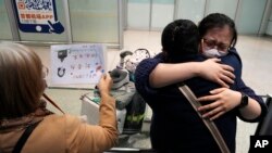 2023年3月14日，北京首都國際機場一名女子等到了乘坐國際航班抵達北京的親人。（美聯社照片）