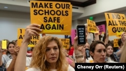 Un grupo de madres levanta carteles que piden más seguridad en las escuelas al comenzar una audiencia civil después de un tiroteo en una escuela de Nashville, Tennessee, EEUU, el 22 de agosto de 2023.