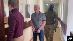 FILE - In this handout photo taken from video released by Lefortovo District Court, Robert Shonov walks to the courtroom at the Lefortovo District Court in Moscow, May 18, 2023.