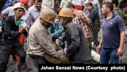 معدنچیان در حال خروج پیکر یکی از همکاران کشته شده خود هستند.
