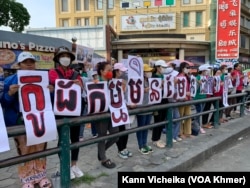 រូបឯកសារ៖ ក្រុមបុគ្គលិក និងសហជីពណាហ្គាវើលដ៍ ឈរលើកបដា និងរូបថត គាំទ្រថ្នាក់ដឹកនាំសហជីពរបស់ខ្លួន នៅខឿនផ្លូវម្ខាងទៀតពីមុខតុលាការ នៅថ្ងៃទី២៥ ខែឧសភា ឆ្នាំ២០២៣ ក្នុងអំឡុងការប្រកាស​សាលក្រម​រឿងក្តីរបស់កញ្ញា ឈឹម ស៊ីថរ។ (កាន់ វិច្ឆិកា/វីអូអេ)