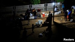 People gather to get water using a generator due to a power cut as clashes between Sudan's paramilitary Rapid Support Forces and the army continue, in Khartoum North, Sudan, May 12, 2023.