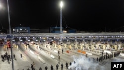 Vue aérienne d'agents des douanes et de la protection des frontières des États-Unis effectuant un exercice au port de passage de San Ysidro, à la frontière américano-mexicaine, vu de Tijuana, dans l'État de Basse-Californie, au Mexique, le 10 mai 2023.