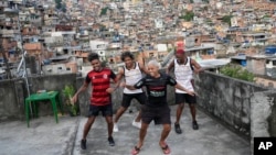 Youth perform a street dance style known as passinho for their social media accounts, in the Rocinha favela of Rio de Janeiro, Brazil, Wednesday, April 17, 2024. (AP Photo/Silvia Izquierdo) 