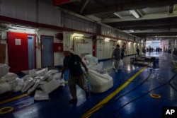 Para pekerja mempersiapkan kapal Freedom Flotilla Coalition saat berlabuh di pelabuhan Tuzla di Istanbul, Turki, Jumat, 19 April 2024. (AP/Khalil Hamra)