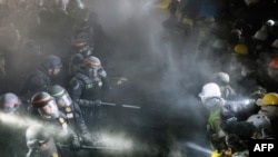 在加州大學洛杉磯分校，在校園抗議營地的障礙被部分拆毀後，警方與支持巴勒斯坦人的抗議學生對峙。 (2024年5月2日)