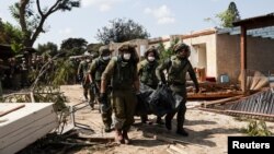 Izraelski vojnici iznose vreće sa tijelima ubijenih stanovnika kibuca Kfar Aza poslije napada militantnog pokreta Hamas (Foto: Reuters/Violeta Santos Moura)