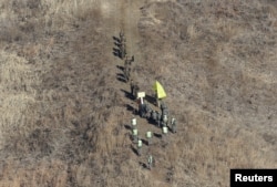 Tentara Korea Utara, atas, melintasi Garis Demarkasi Militer di dalam Zona Demiliterisasi (DMZ) untuk memeriksa pos penjagaan Korea Selatan yang dibongkar, 12 Desember 2018. (Foto: via Reuters)