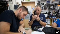 Seorang pria Israel membeli senjata di toko senjata dekat pemukiman Yahudi di Tepi Barat, Givat Zeev, Minggu, 11 Oktober 2015. (AP/Dan Balilty)