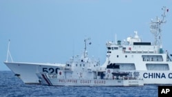 Sebuah kapal Penjaga Pantai China dengan nomor haluan 5201 menghadang kapal Penjaga Pantai Filipina BRP Malapascua saat bermanuver memasuki muara Second Thomas Shoal yang dikenal sebagai Ayungin Shoal di Laut Cina Selatan pada Minggu, 23 April 2023. (AP/Aaron Favila)