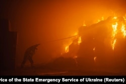 In this photo by Pavlo Petrov and the Press Service of the State Emergency Service of Ukraine, a firefighter works at a tobacco factory damaged during Russia's attack on Ukraine, in Kyiv, May 28, 2023.