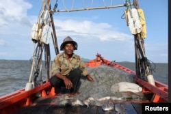 Fisherman Ung Bun, 39, sits in his boat out at sea off the coast of Cambodia's southern Kep province, Cambodia August 18, 2023. (REUTERS/Thomas Suen)
