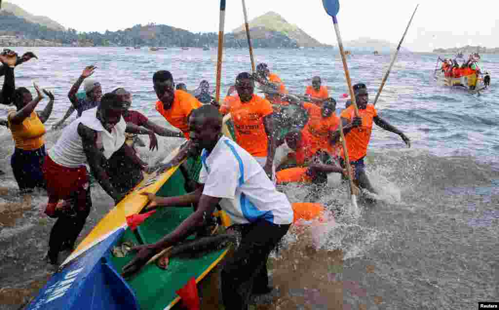 Warga menyoraki peserta dalam festival lomba balap perahu tradisional Kafuke, yang menjadi bagian dari perayaan Natal, di Danau Victoria, Kenya, pada 24 Desember 2023. (Foto: Reuters/Thomas Mukoya)