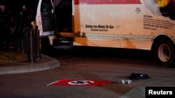 Nacistička zastava i drugi predmeti pronađeni u iznajmljenon kamionetu leže na zemlji, dok pripadnici tajne služba i drugih agencije za sprovođenje zakona istražuju vozilo koje se zabilo u bezbednosne barijere u parku Lafajet preko puta Bele kuće u Vašingtonu, 23. maja 2023.