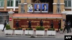 FILE - Police officials walk in front of Phnom Penh Municipal Court in Phnom Penh on March 17, 2022. 