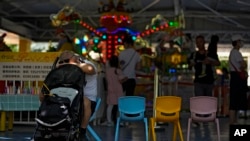 A man rests against a baby stroller during International Children's Day in Beijing, June 1, 2021. News of a hospital obstetrics department shutdown became the top topic on China's most popular chat platform this week, prompting discussions about having children — or not. 