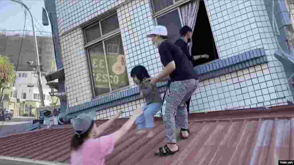 Residentes rescatan a un niño de un edificio parcialmente derrumbado en Hualien.