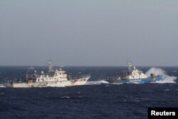 រូបឯកសារ៖ នាវារបស់កងឆ្មាំជើងទឹកវៀតណាមធ្វើដំណើរនៅក្បែរនាវារបស់កងឆ្មាំសមុទ្ររបស់ចិន នៅតំបន់សមុទ្រចិនខាងត្បូង ស្ថិតក្នុងចម្ងាយ ២១០គីឡូម៉ែត្រ ពីឆ្នេរវៀតណាម កាលពីថ្ងៃទី ១៤ ខែឧសភា ឆ្នាំ ២០១៤។