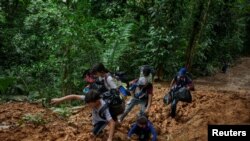 Una familia de migrantes venezolanos con niños atraviesa la selva colombiana en el Tapón del Darién, en una peligrosa y agotadora caminata de cinco a siete días. En Colombia, el 27 de julio de 2022. Foto: Fundación Thomson Reuters/Fabio Cuttica