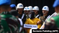 Polisi Militer mengawal satu dari enam tentara yang menjadi tersangka pembunuhan empat orang asli Papua untuk rekonstruksi di Mimika, Papua, 3 September 2022. (Foto: Sevianto Pakiding/AFP/arsip)