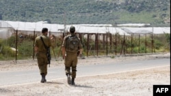 2022年4月13日，以色列士兵在以色列中部Ibthan附近的安全围栏旁巡逻，该围栏将以色列与被占领的约旦河西岸隔开。