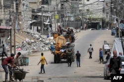 Para pria duduk di belakang truk yang memuat perabotan dan barang-barang lainnya saat mereka melarikan diri menuju Khan Yunis, di Rafah di selatan Jalur Gaza pada 11 Mei 2024. (Foto: AFP)