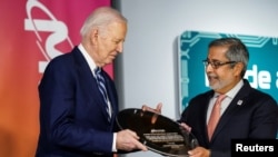 美光科技公司首席执行官桑贾伊·梅洛特拉在拜登访问纽约州雪城期间把一片晶圆送给美国总统乔·拜登。(2024年4月25日)