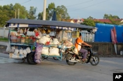 អាជីវករម្នាក់ដឹកទំនិញលក់តាមតូបចល័ត នៅជាយរាជធានីភ្នំពេញ កាលពីថ្ងៃទី ២០ ខែកញ្ញា ឆ្នាំ ២០២៣។