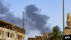 Moshi unapaa juu nyuma ya majengo mjini Khartoum, Aprili 19, 2023, huku mapigano kati ya jeshi na wanamgambo yakipamba moto kwa siku ya tano mfululizo.